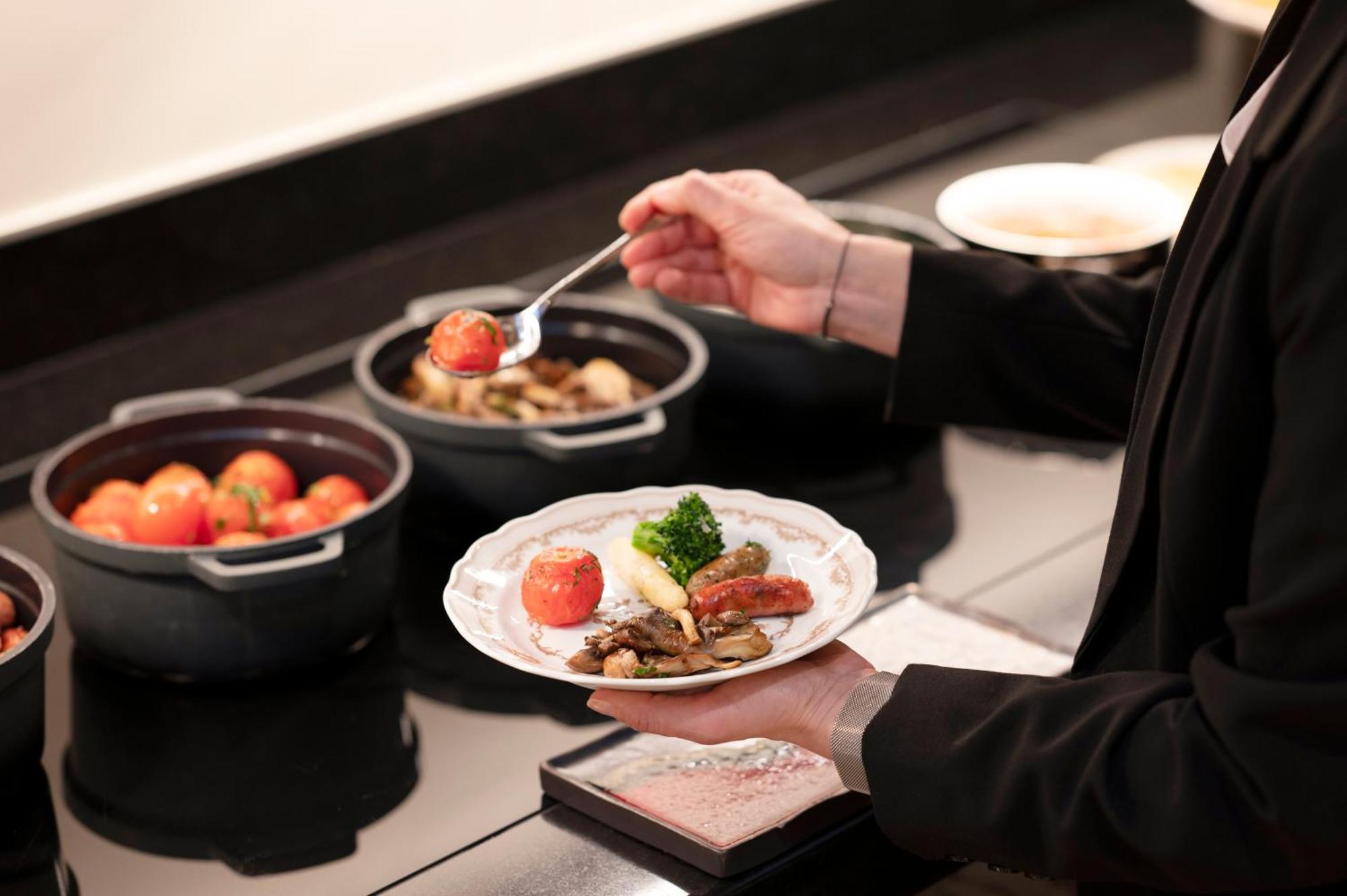 בריסל Stanhope Hotel By Thon Hotels מראה חיצוני תמונה A server prepares a plate of food